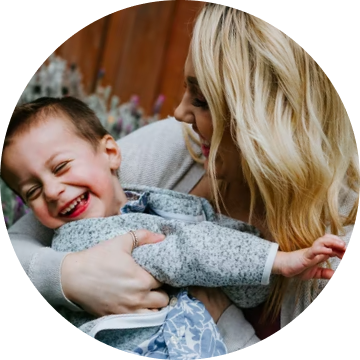 Baby giggling to his mother, sitting on his mother's lap